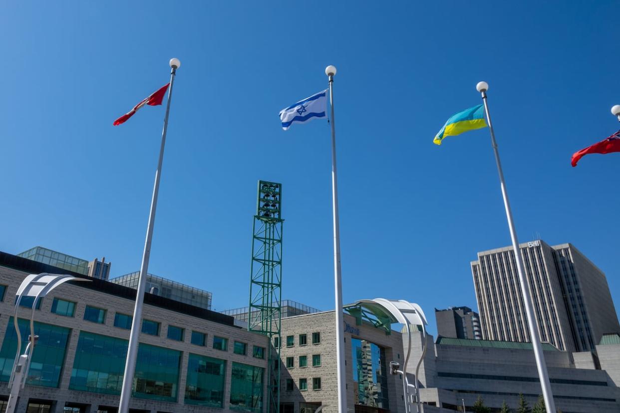 Flags for Canada, Israel and Ukraine fly at full mast over Ottawa City Hall on May 5, 2022. A private ceremony in recognition of Israel's Independence Day will take place on Tuesday, after initial plans for a public flag-raising event were called off.  (Francis Ferland/CBC - image credit)