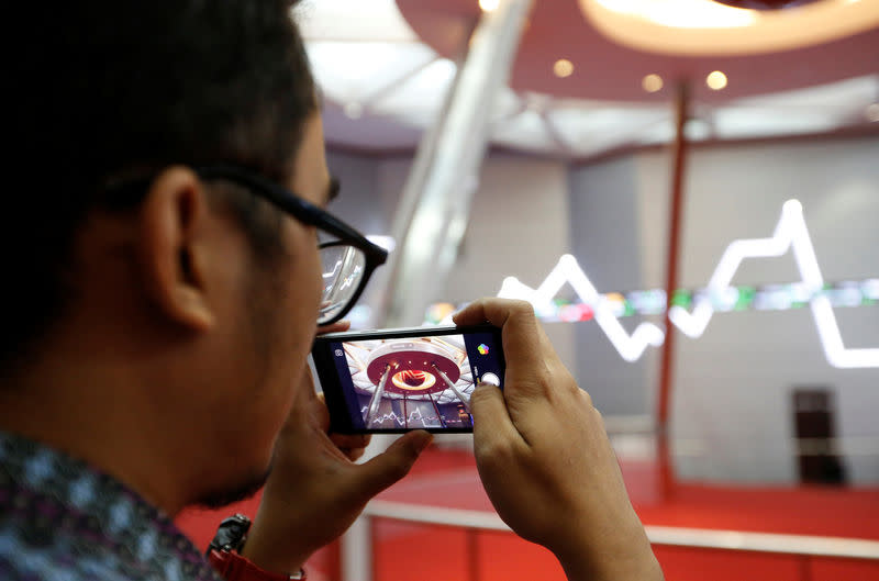 A man takes pictures inside the Indonesia Stock Exchange building in Jakarta, Indonesia, September 6, 2018. REUTERS/Willy Kurniawan/Files