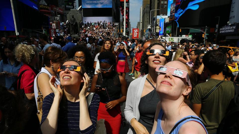 PHOTO: People gather to observe the total solar eclipse with solar eclipse glasses at the Times Square in New York City, Aug. 21, 2017.  (Volkan Furuncu/Getty Images)
