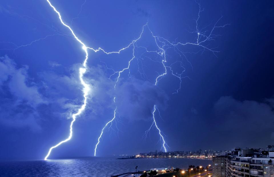 TOPSHOT – Lightning strikes during a thunderstorm in Montevideo on February 20, 2022. (Photo by Mariana SUAREZ / AFP) (Photo by MARIANA SUAREZ/AFP via Getty Images)