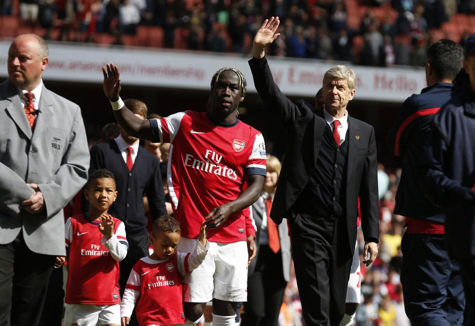 Arsenal's manager Arsene Wenger, center right, and Bacary Sagna, center left, wave to the supporters as the team parade around the stadium in their last home match of the season, after their English Premier League soccer match against West Bromwich Albion at Emirates Stadium in London, Sunday, May 4, 2014. (AP Photo/Sang Tan)