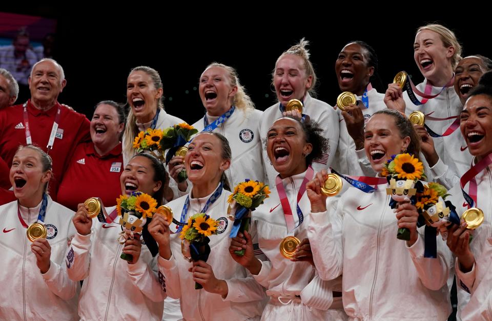 The U.S. women's volleyball team celebrates with their gold medals.