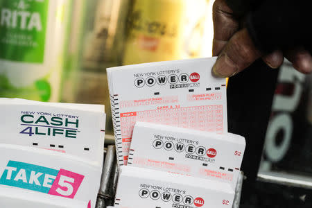 A customer buys tickets for the PowerBall lottery in New York City, U.S., March 17, 2017. REUTERS/Jeenah Moon