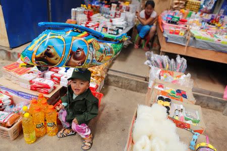 A boy dressed as United Wa State Army (UWSA) soldier, sits in a market at Mongmao, Wa territory in northeast Myanmar October 1, 2016. Picture taken on October 1, 2016. REUTERS/Soe Zeya Tun