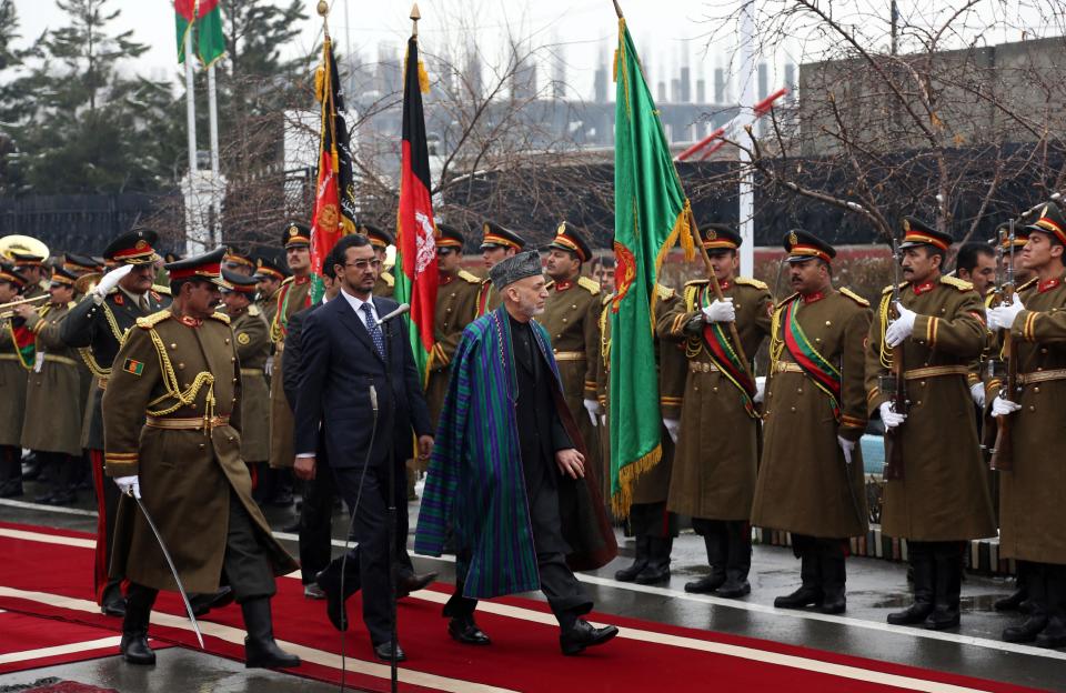 Afghan President Hamid Karzai, center, arrives at an opening session at the parliament house in Kabul, Afghanistan, Saturday, March 15, 2014. Karzai said the last 12 years of war were "imposed" on Afghans, a reference to the U.S.-led invasion that ousted the Taliban. (AP Photo/Rahmat Gul)