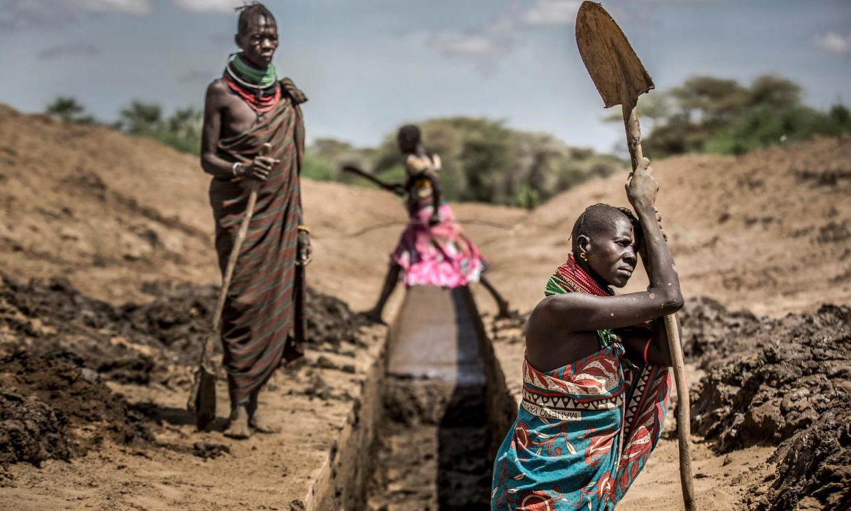 <span>People in Kenya work to unblock an irrigation canal to provide water to crops amid recurring and prolonged droughts.</span><span>Photograph: Luis Tato/AFP/Getty Images</span>