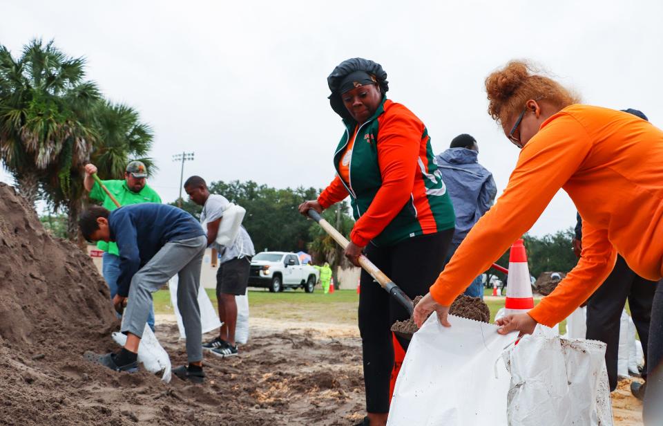 Tameika Greenlee, 42, fills a bag with sand on Wednesday as she prepares for the arrival of Hurricane Ian, at Citizens Field in Gainesville. Helping Greenlee is her daughter Samara Hawkins, 22.