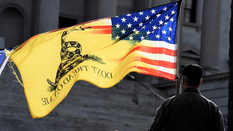 A man holds a flag and listens to a speaker during a rally at South Carolina’s Statehouse on Sunday, Jan. 17, 2021, in Columbia, S.C.