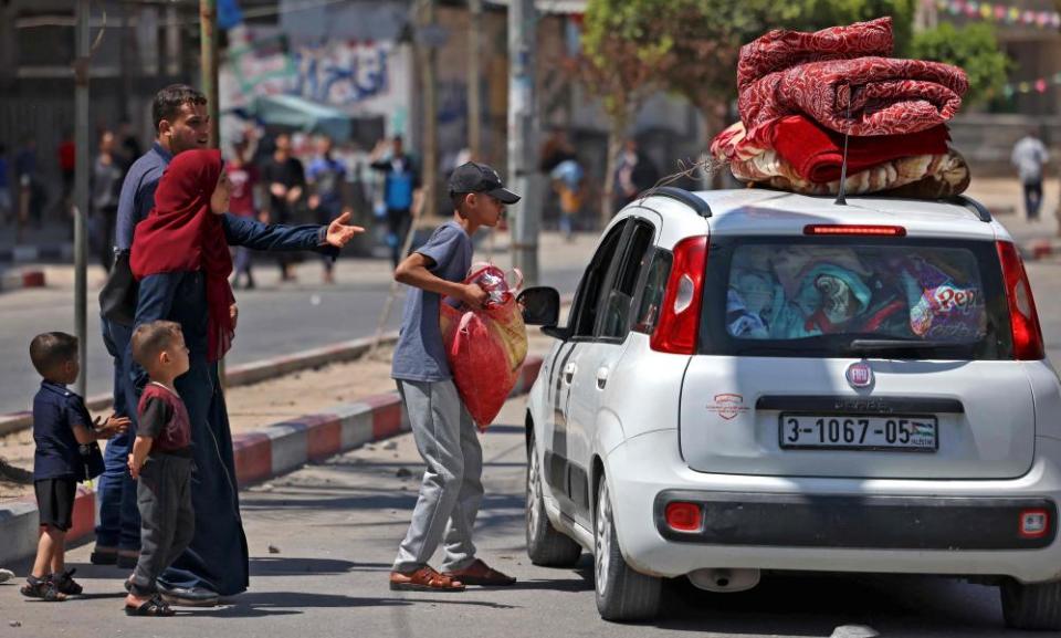 A Palestinian family flees with their belongings stacked on top of a car in Beit Hanun in the northern Gaza Strip