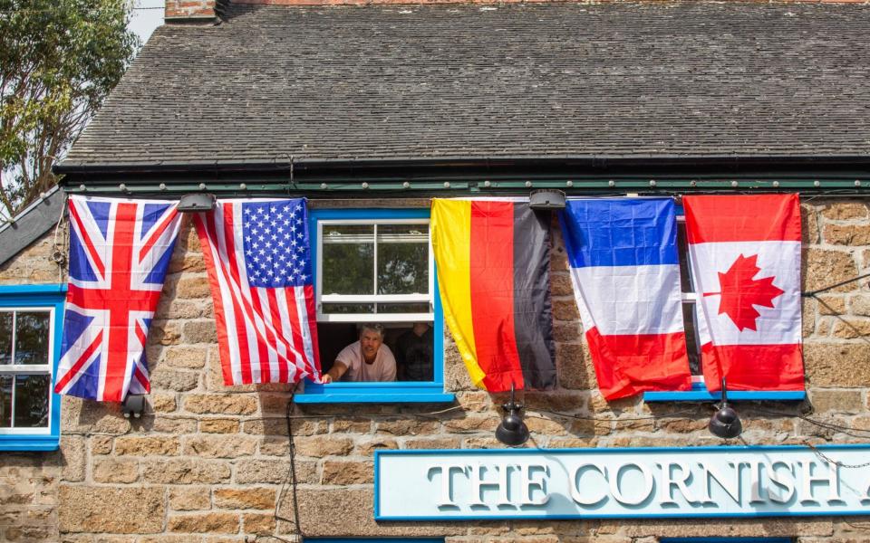 Dave Upton from The Cornish Arms pub in Carbis Bay, Cornwall, has decorated his pub with all seven flags of the countries taking part  - SWNS