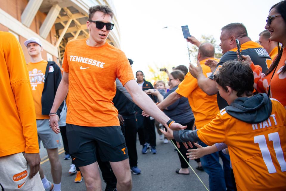 Tennessee's Dalton Knecht gives a high five to a young Vols fan during the Vol Walk held before Tennessee's Orange & White spring football game April 13.