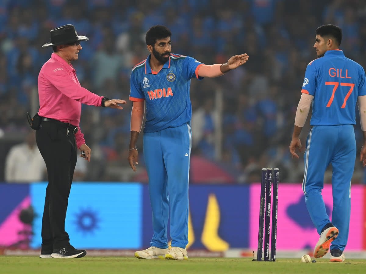 Jasprit Bumrah and Shubman Gill interact with Match Umpire Richard Kettleborough during the ICC Men's Cricket World Cup India 2023 Fina (Getty Images)