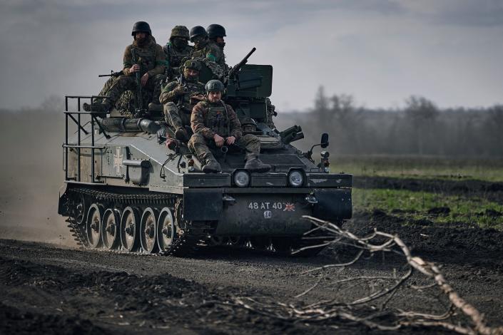 Ukrainian soldiers ride atop an APC on the frontline in Bakhmut, Donetsk region, Ukraine, Sunday, March 26, 2023.