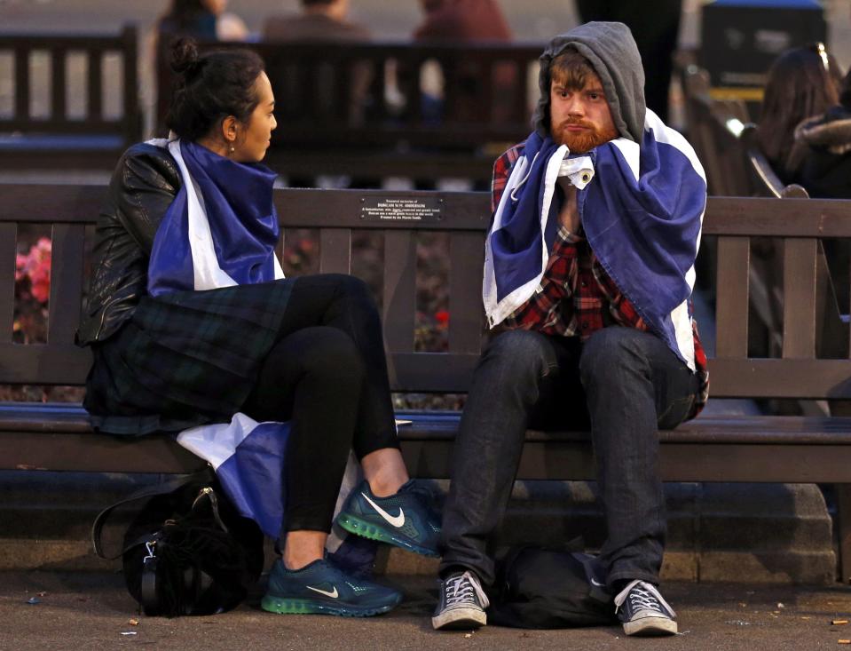 Dejected supporters from the "Yes" Campaign sit on a bench in George Square in Glasgow, Scotland