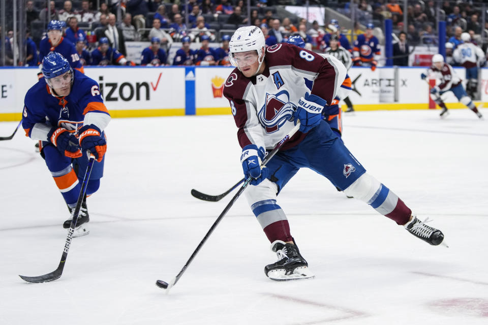 Colorado Avalanche's Cale Makar (8) shoots the puck past New York Islanders' Ryan Pulock (6) for a goal during the first period of an NHL hockey game Tuesday, Oct. 24, 2023, in Elmont, N.Y. (AP Photo/Frank Franklin II)