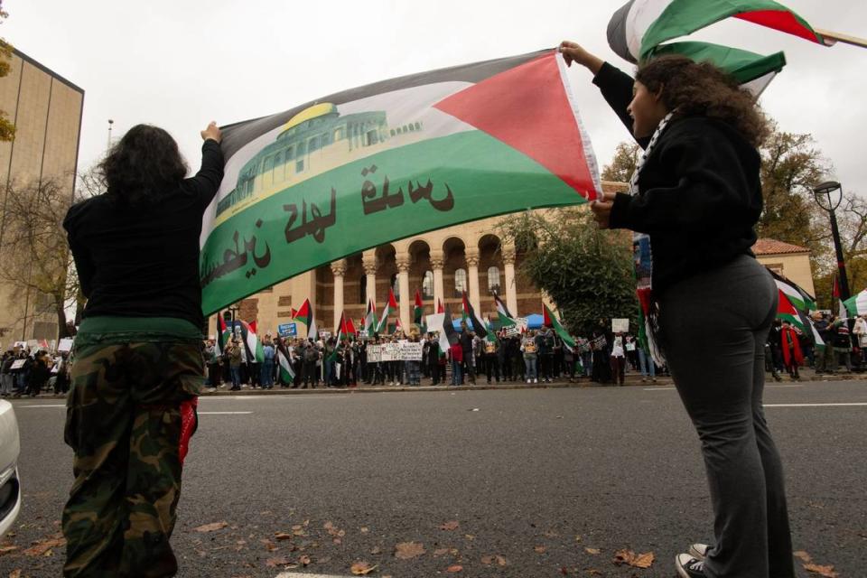 Demonstrators hold a Palestinian flag at the Memorial Auditorium in Sacramento on Saturday, during a protest calling for a cease-fire in the Israel-Hamas war.