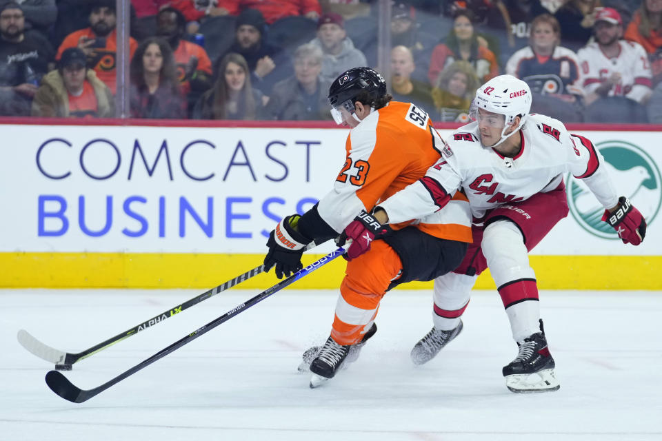 Philadelphia Flyers' Lukas Sedlak, left, and Carolina Hurricanes' Jesperi Kotkaniemi battle for the puck during the second period of an NHL hockey game, Saturday, Oct. 29, 2022, in Philadelphia. (AP Photo/Matt Slocum)