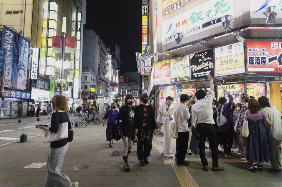 People hang out in the famed Kabukicho neighborhood in Tokyo on Friday, May 28, 2021. With infections and serious cases rising despite a state of emergency, Prime Minister Yoshihide Suga has begun all-out efforts, from deploying military doctors and nurses at mass inoculation centers to allowing legal exceptions to recruit more people to give shots. But the realization here that it may be too little, too late to make a difference during the Olympics is starting to dawn. (AP Photo/Hiro Komae)