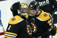 Boston Bruins goaltender Jeremy Swayman (1) and defenseman Brandon Carlo (25) celebrate their victory over the New York Rangers after an NHL hockey game, Thursday, May 6, 2021, in Boston. (AP Photo/Elise Amendola)