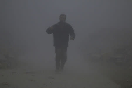 A man covered with dust walks at a site hit by an airstrike in the rebel-held al-Ansari neighbourhood of Aleppo, Syria December 7, 2016. REUTERS/Abdalrhman Ismail