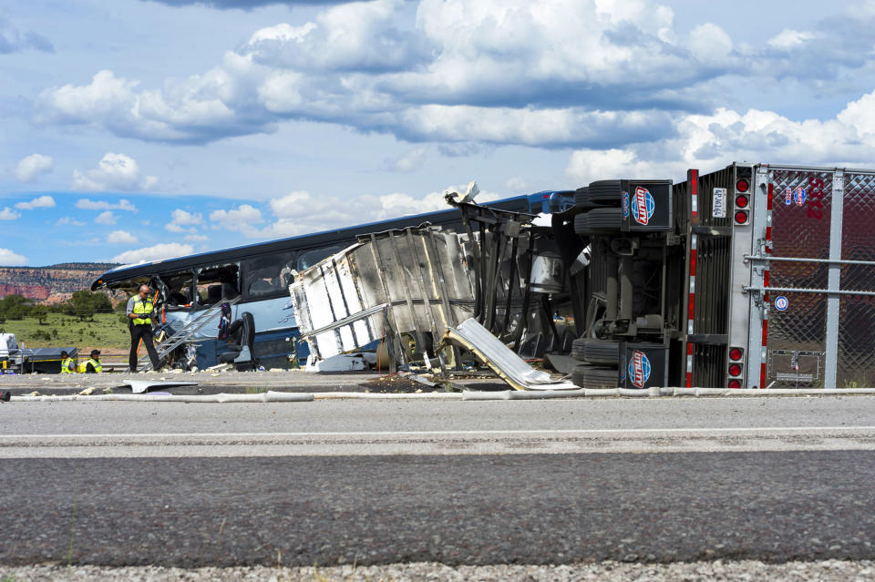 This Thursday, Aug. 30, 2018 photo shows investigators at the scene of the collision of a semitrailer that crossed the median of Interstate 40 and crashed head-on into a Greyhound bus near Thoreau, N.M. A California-based trucking company and one of its drivers were accused of negligence Friday in a pair of lawsuits as investigators sorted through the wreckage from the deadly bus crash on the New Mexico highway. (Brandon N. Sanchez/Gallup Independent via AP)