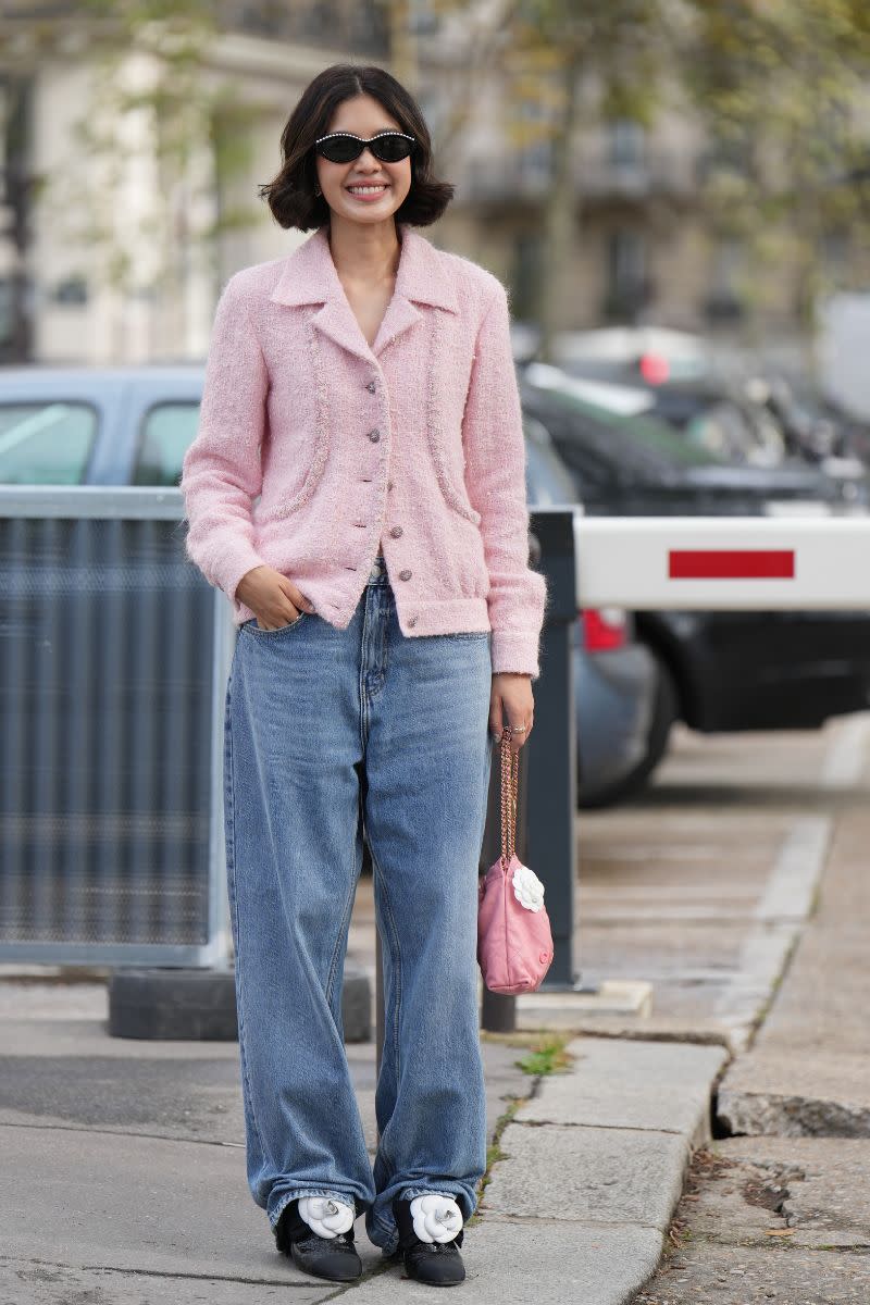 <p> If you want to wear Barbiecore in a grown up way try a pastel toned knit with smart wide leg jeans like this guest at the Chanel SS24 show. Her more formal jacket gives a fun contrast to her soft, slouchy jeans while her ladylike accessories add a whimsical twist to the look. </p>