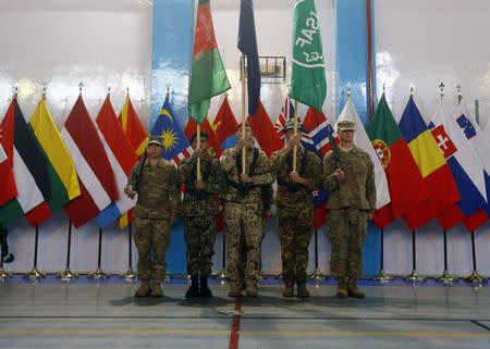 Afghan and NATO-led International Security Assistance Force (ISAF) soldiers stand at attention during the change of mission ceremony in Kabul, December 28, 2014 REUTERS/Omar Sobhani