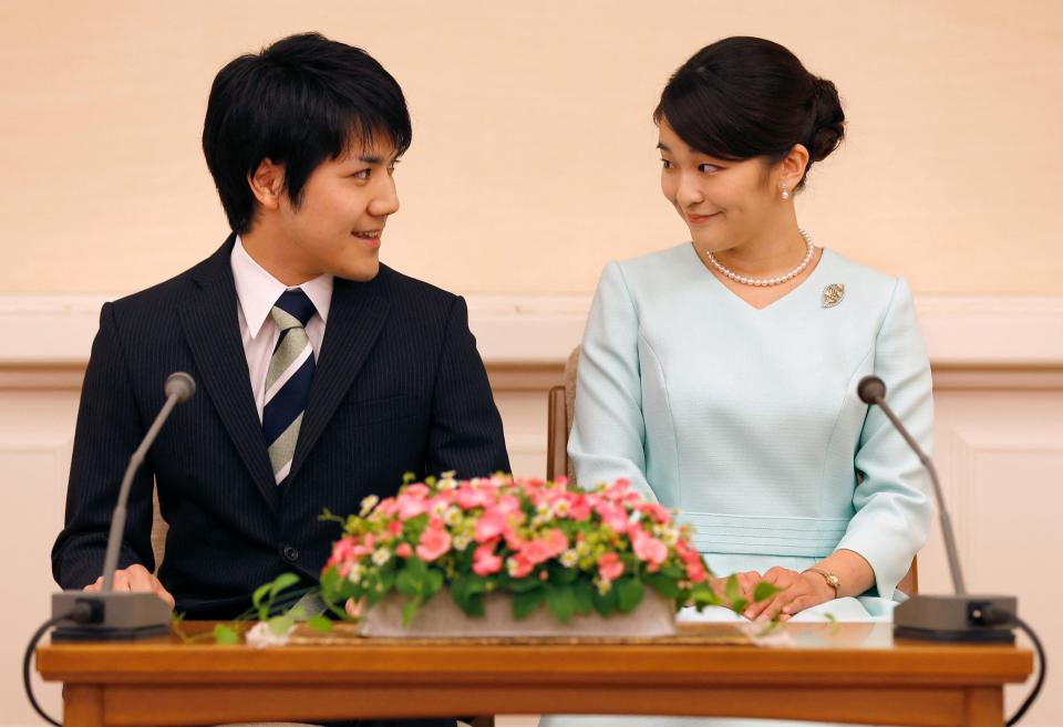 (FILES) This file photo taken on September 3, 2017 shows Japan's Princess Mako (R), the eldest daughter of Prince Akishino and Princess Kiko, looking at her fiancée Kei Komuro (L), as they meet the media during a press conference to announce their engagement at the Akasaka East Residence in Tokyo. Japan's Princess Mako is expected to marry her university sweetheart Kei Komuro on October 26, 2021, but she will forego traditional rites and will not take a usual payment given to royal women marrying commoners. / AFP / POOL / Shizuo Kambayashi