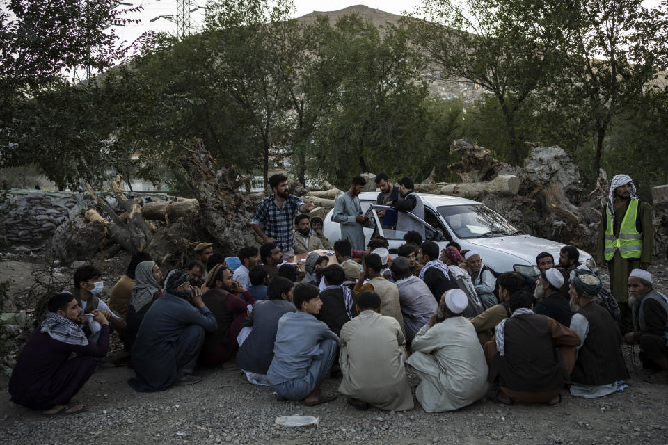 Displaced Afghans wait for food donations at a camp for internally displaced persons in Kabul, Afghanistan, Monday, Sept. 13, 2021. (AP Photo/Bernat Armangue)