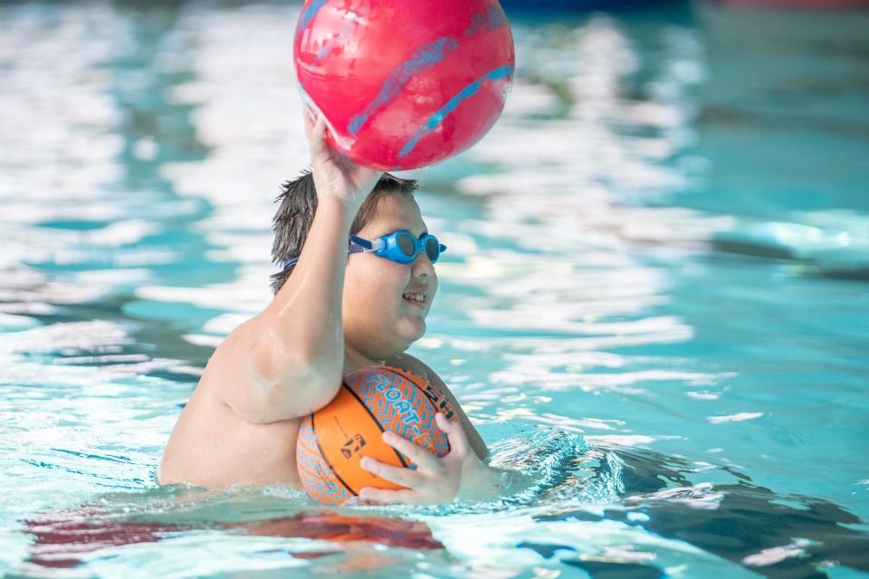 Johnny Franklin tosses a ball to his mom Maria during a new sensory swim program for people with disabilities at the Pueblo Regional Center swimming pool on Friday, Jan. 13, 2023.