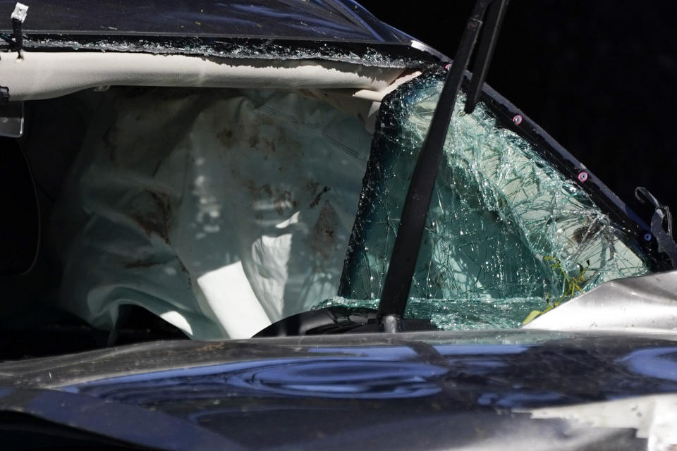 A vehicle is towed away from the site of a crash involving golfer Tiger Woods, Tuesday, Feb. 23, 2021, in the Rancho Palos Verdes suburb of Los Angeles. (AP Photo/Ashley Landis)