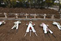 Wreaths lie atop the new graves of recent fatalities of the coronavirus pandemic in the northern city of Thessaloniki, Greece, on Wednesday, Dec. 2, 2020. Greece has been battling a resurgence of the virus that has led to record numbers of daily deaths. A nationwide lockdown imposed in early November has been extended until Dec. 7. (AP Photo/Giannis Papanikos)