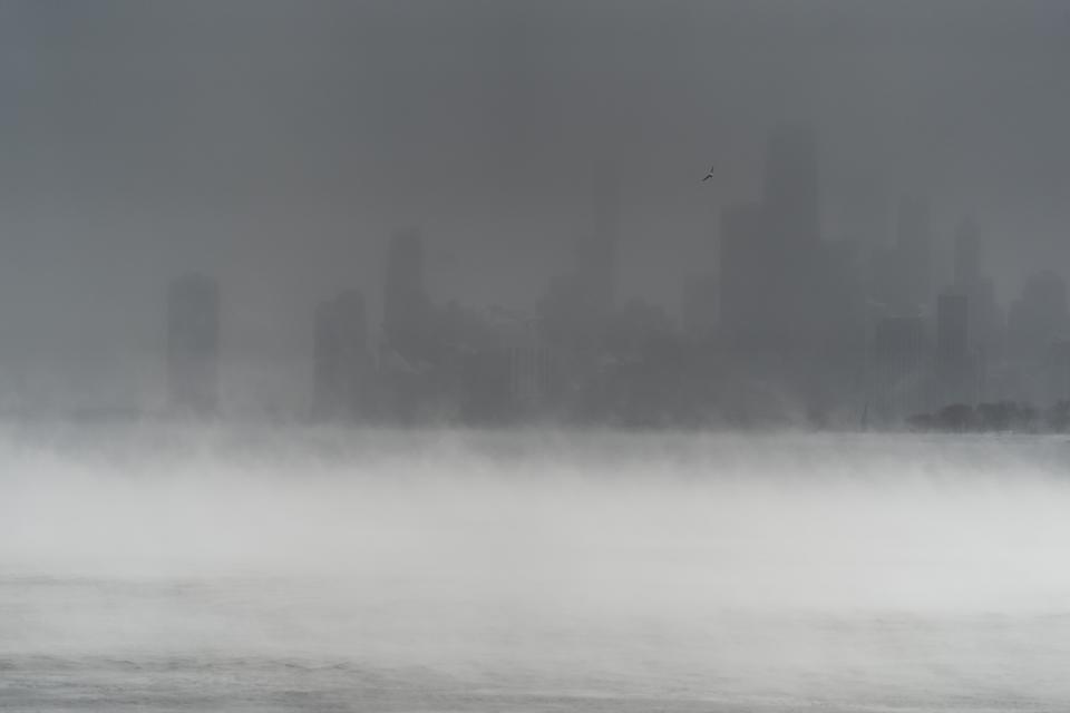 The downtown Chicago skyline is obscured by blowing snow and steam rising from Lake Michigan as seen from Montrose Harbor, Friday, Dec. 23, 2022, in Chicago. (AP Photo/Erin Hooley)