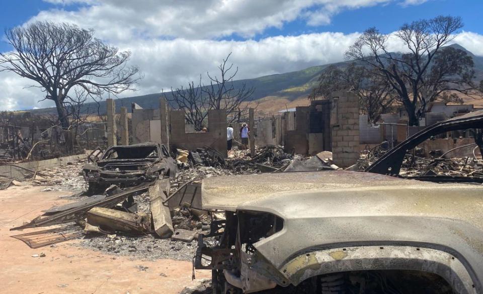 Residents walk among their destroyed home in the aftermath of a wildfire in Lahaina, western Maui, Hawaii.