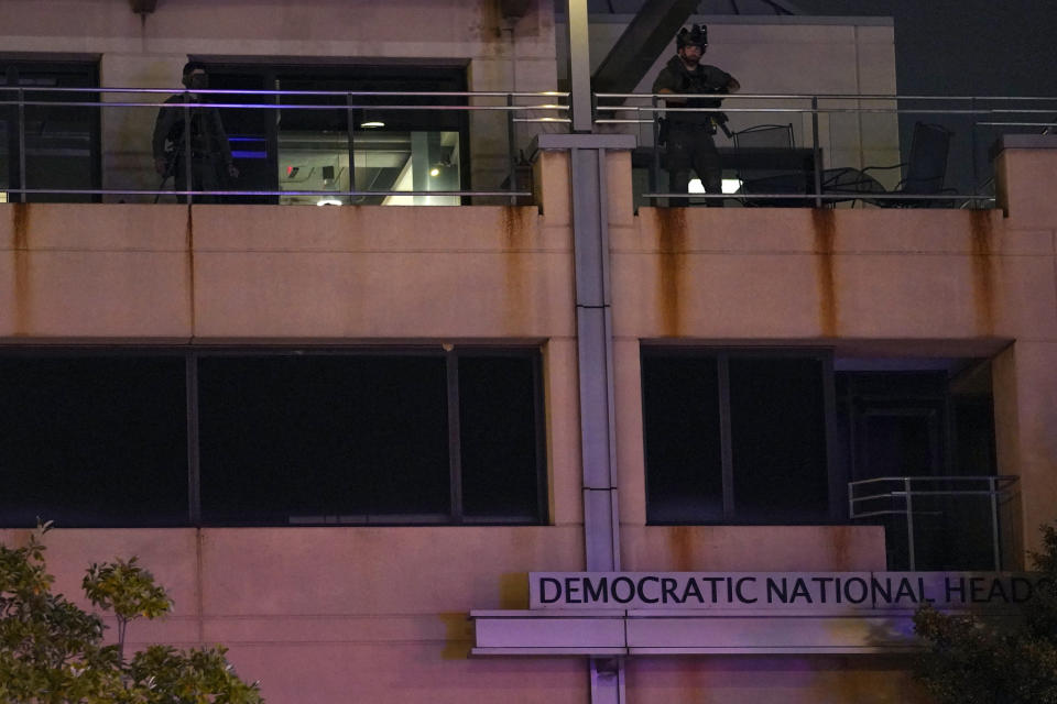 U.S. Capitol Police officers stand on a balcony at the headquarters of the Democratic National Committee Wednesday, Nov. 15, 2023, in Washington, after a protest. (AP Photo/Nathan Howard)
