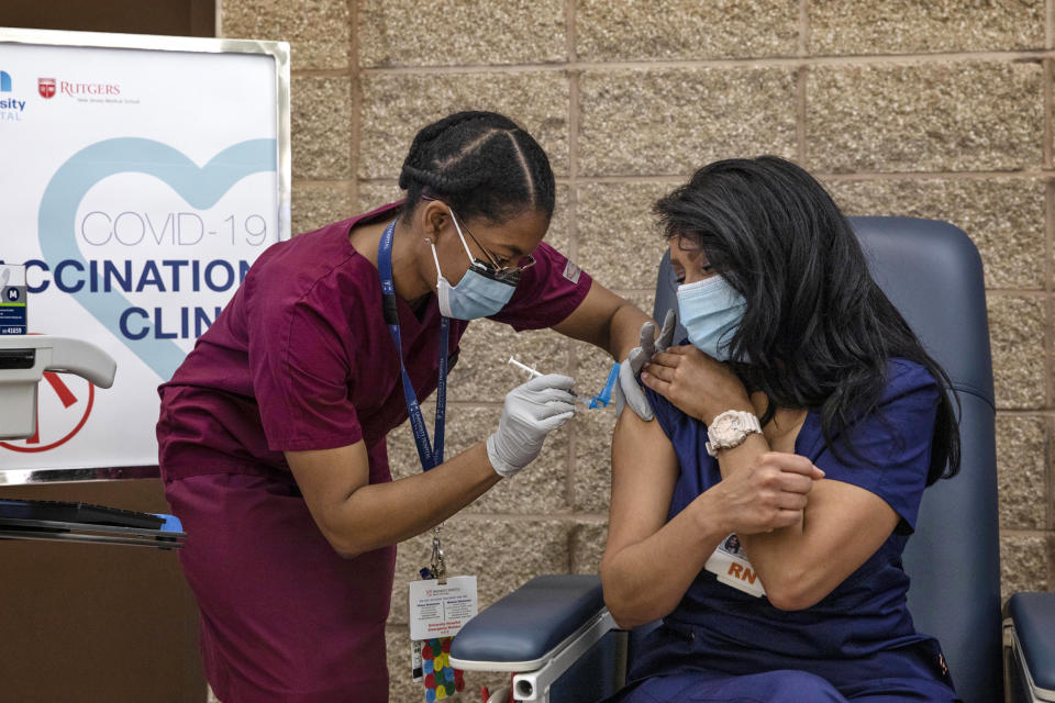 Nurse Maritza Beniquez, right, became the first person in New Jersey to get the shot when she received the Pfizer-BioNTech vaccine at University Hospital, in Newark on Dec. 15. (Kirsten Luce / Pool via AP)