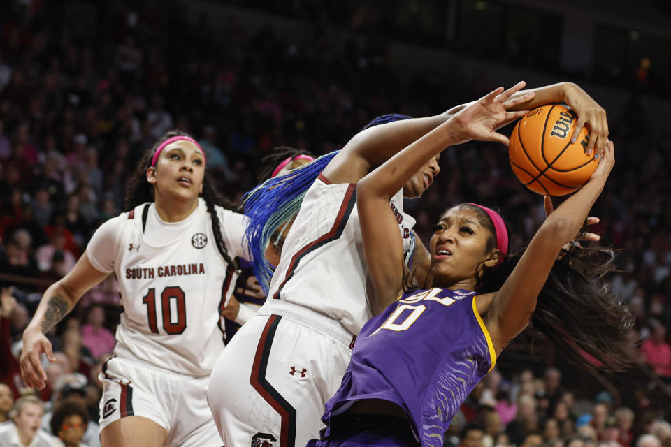 South Carolina forward Aliyah Boston, center, strips the ball from LSU forward Angel Reese, right, as South Carolina center Kamilla Cardoso (10) looks on during the second half of an NCAA college basketball game in Columbia, S.C., Sunday, Feb. 12, 2023. (AP Photo/Nell Redmond)