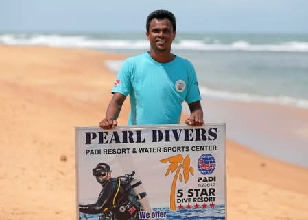 Nuwan Harshana, 31, manager at Pearl Divers, a diving school, poses for a photograph during an interview with Reuters, near his hotel at Unawatuna beach in Galle