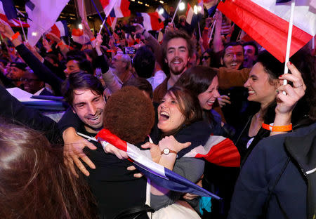 Supporters of Emmanuel Macron, head of the political movement En Marche !, or Onwards !, and candidate for the 2017 French presidential election, react after early results in the first round of 2017 French presidential election, in Paris, France, April 23, 2017. REUTERS/Philippe Wojazer