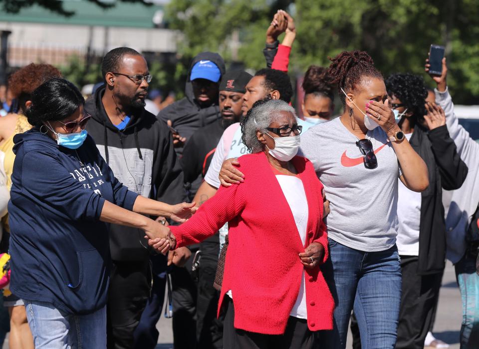 Odessa  Riley, center in red sweater, was escorted by family members June 1 to the site where her son was fatally shot at 26th and Broadway in Louisville, Ky.