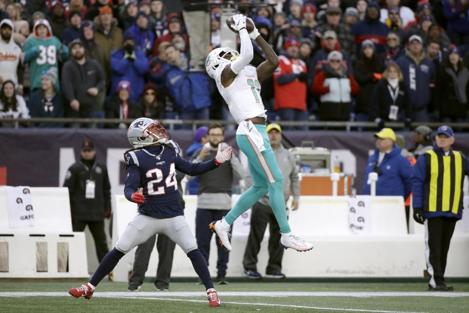 Miami Dolphins wide receiver DeVante Parker catches a pass over New England Patriots cornerback Stephon Gilmore in the second half of an NFL football game, Sunday, Dec. 29, 2019, in Foxborough, Mass. (AP Photo/Elise Amendola)