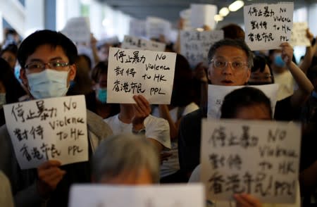 Protesters hold signs following a day of violence over a proposed extradition bill, outside the Legislative Council building in Hong Kong