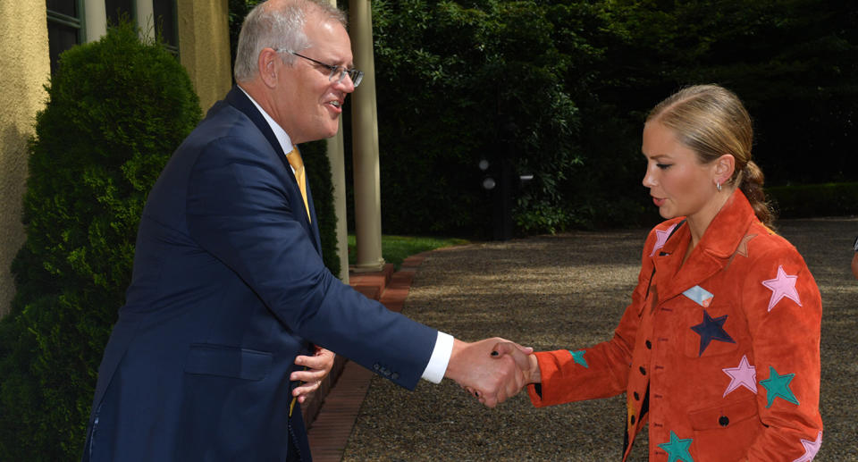 Prime Minister Scott Morrison shakes the hand of Grace Tame, as she avoids eye contact.