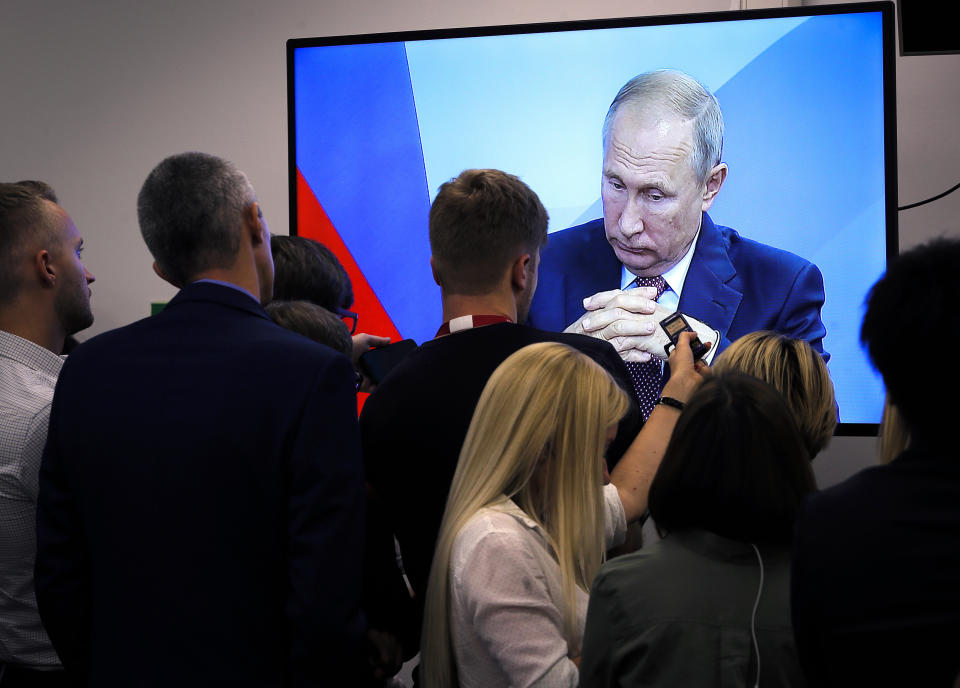 Journalists watch a broadcast of the meeting of Russian President Vladimir Putin and Japanese Prime Minister Shinzo Abe at the Eastern Economic Forum in Vladivostok, Russia, Monday, Sept. 10, 2018. (AP Photo/Dmitri Lovetsky)