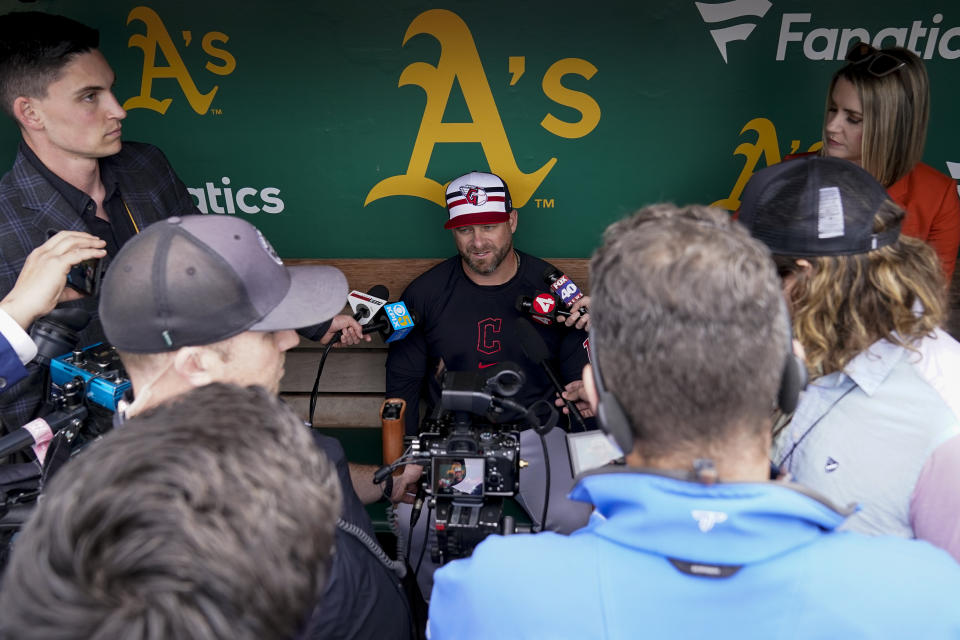 Cleveland Guardians manager Stephen Vogt, center, speaks to reporters before the team's baseball game against the Oakland Athletics, Thursday, March 28, 2024, in Oakland, Calif. (AP Photo/Godofredo A. Vásquez)