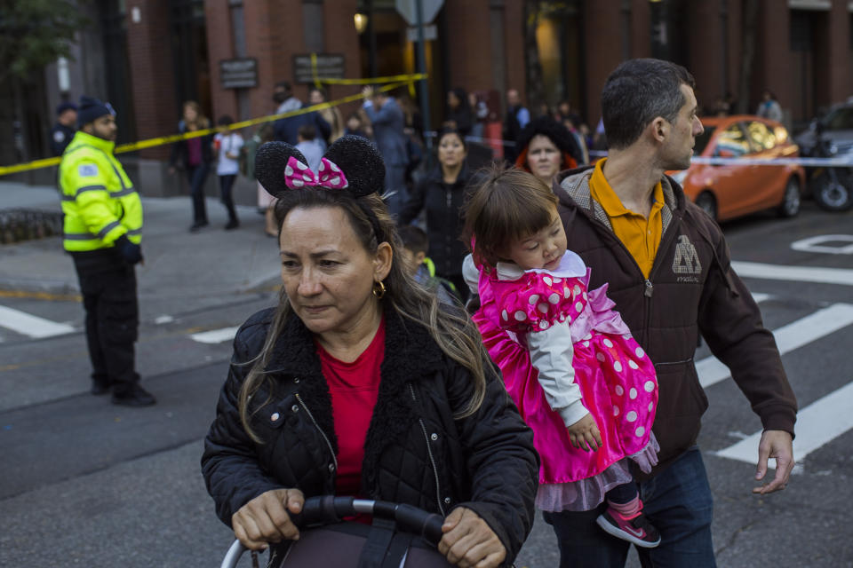 <p>Families carry their children out of the scene after a motorist drove onto a busy bicycle path near the World Trade Center memorial and struck several people Tuesday, Oct. 31, 2017, in New York. (Photo: Andres Kudacki/AP) </p>