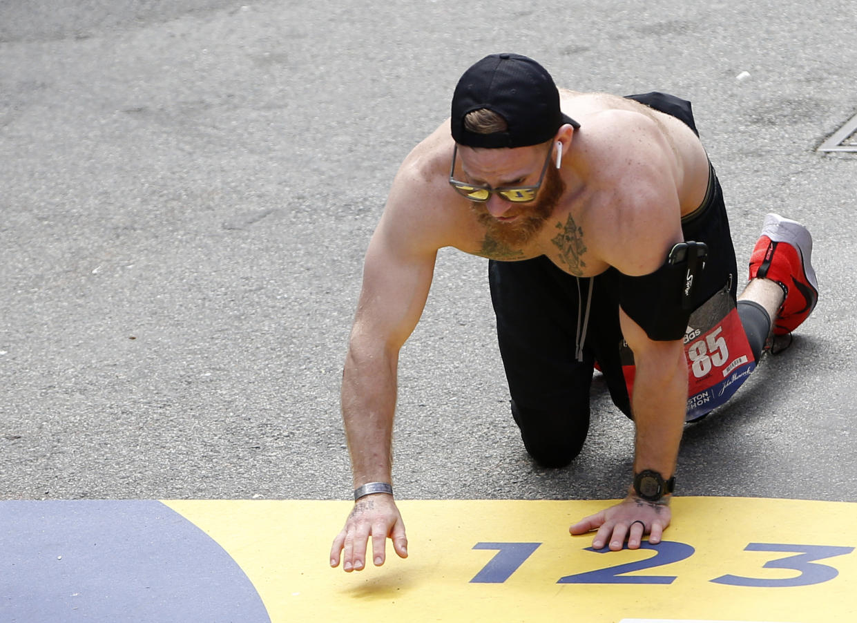 Micah Herndon crosses the finish line of the Boston Marathon on his hands and knees, without assistance, after his legs locked at mile 22. (Photo: Getty Images/ Jessica Rinaldi/Globe Staff)