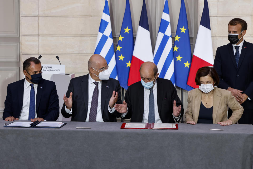 From the left, Greek Prime Minister Kyriakos Mitsotakis, , Greek Foreign Affairs Minister Nikos Dendias, French Foreign Affairs Minister Jean-Yves Le Drian, French Defense Minister Florence Parly and French President Emmanuel Macron attend the signing ceremony of a new defence deal at The Elysee Palace Tuesday, Sept. 28, 2021. France and Greece announced on Tuesday a major, multibillion-euro defense deal including Athens' decision to buy three French warships. (Ludovic Marin, Pool Photo via AP)