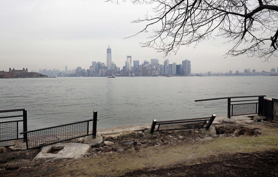 Manhattan island can be scene behind sections of a fence on Liberty Island, in New York, Friday, Nov. 30, 2012. Tourists in New York will miss out for a while on one of the hallmarks of a visit to New York, seeing the Statue of Liberty up close. Though the statue itself survived Superstorm Sandy intact, damage to buildings and Liberty Island's power and heating systems means the island will remain closed for now, and authorities don't have an estimate on when it will reopen. (AP Photo/Richard Drew)