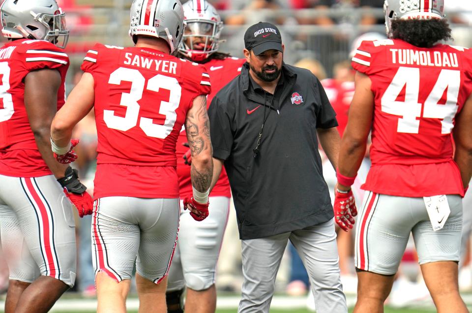 Sep 09, 2023; Columbus, OH, USA; Ohio State Head Coach Ryan Day shakes hands with Ohio State Buckeyes defensive end Jack Sawyer (33) and Ohio State Buckeyes defensive end JT Tuimoloau (44) as he watches the team during warmups before their game against Youngstown State at Ohio Stadium.